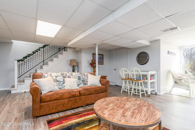 living room featuring a paneled ceiling and wood-type flooring