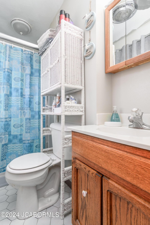 bathroom with tile patterned floors, vanity, walk in shower, and toilet