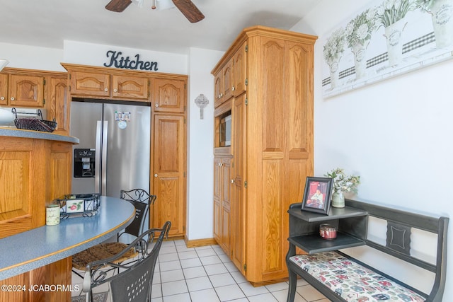 kitchen with stainless steel refrigerator with ice dispenser, light tile patterned floors, and ceiling fan