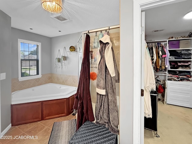 604 Mustang Dr, Ashland, MO 65010 - full bath featuring a garden tub, a spacious closet, and tile patterned floors