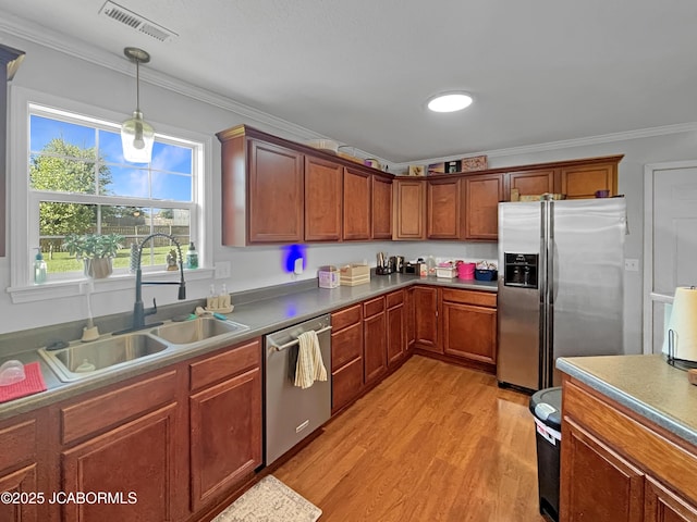 604 Mustang Dr, Ashland, MO 65010 - kitchen featuring stainless steel appliances, ornamental molding, light wood-style flooring, hanging light fixtures, and brown cabinetry