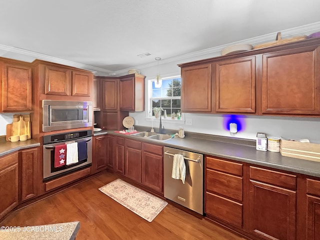 604 Mustang Dr, Ashland, MO 65010 - kitchen with stainless steel appliances, ornamental molding, dark wood-type flooring, hanging light fixtures, and dark countertops