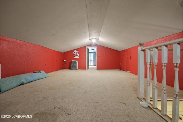 additional living space with vaulted ceiling and carpet flooring