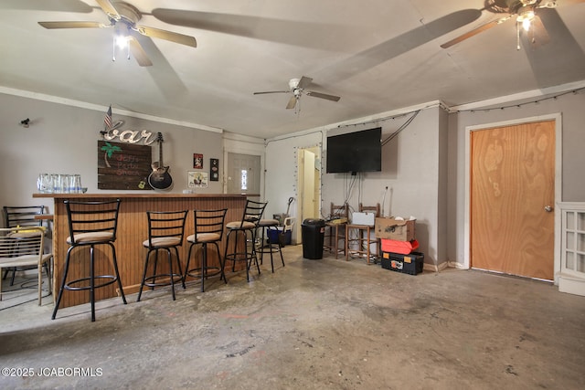 bar with ceiling fan, unfinished concrete flooring, and a bar