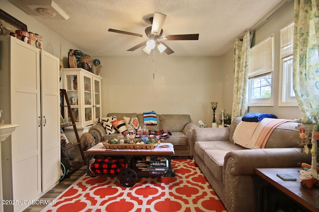 living room with a ceiling fan, a textured ceiling, and wood finished floors