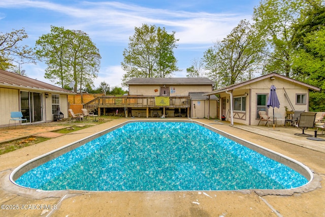 view of pool with a patio, an outdoor structure, a deck, and a fenced in pool