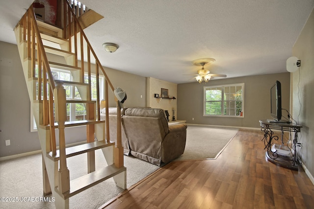 unfurnished living room with stairway, baseboards, and wood finished floors