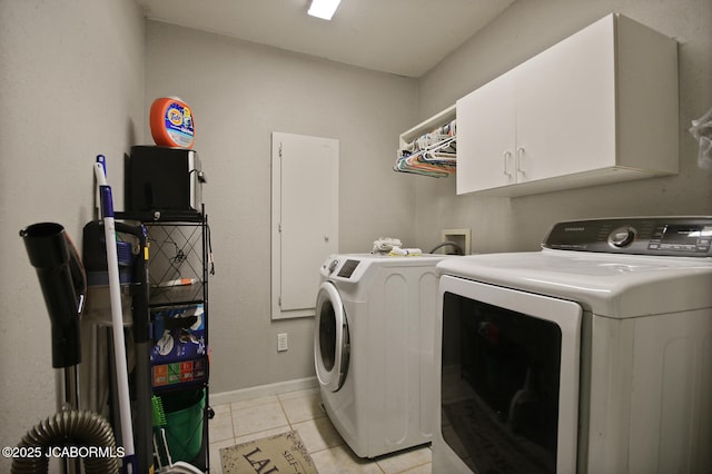 laundry area with light tile patterned floors, separate washer and dryer, baseboards, and cabinet space