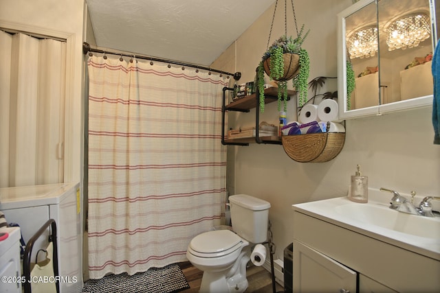 bathroom featuring wood finished floors, vanity, toilet, washer and dryer, and a shower with shower curtain