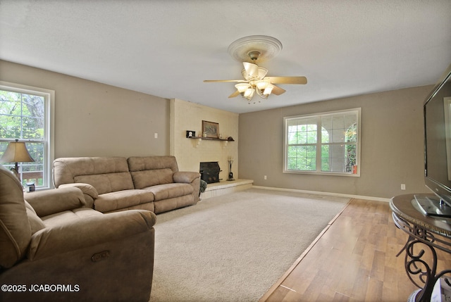 living room with baseboards, ceiling fan, and light wood-style flooring