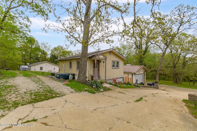 view of front of home featuring a hot tub, an attached garage, and driveway