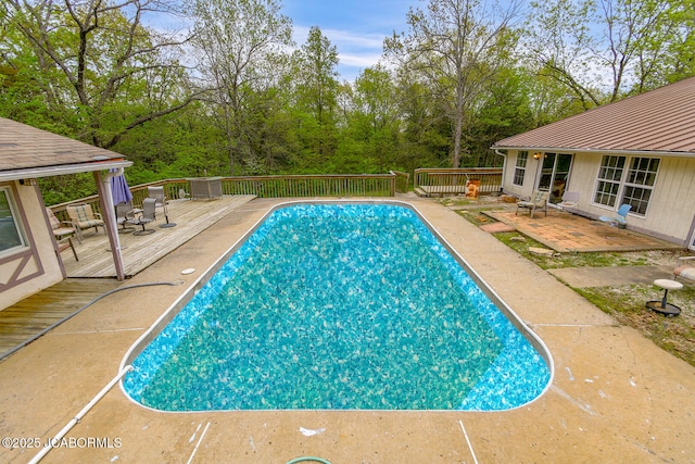 view of swimming pool featuring a fenced in pool, a wooden deck, and cooling unit