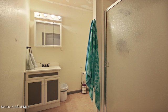 full bathroom with vanity, tile patterned flooring, baseboards, and a shower stall