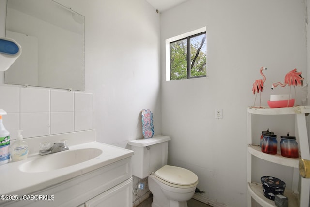 bathroom featuring vanity, backsplash, and toilet
