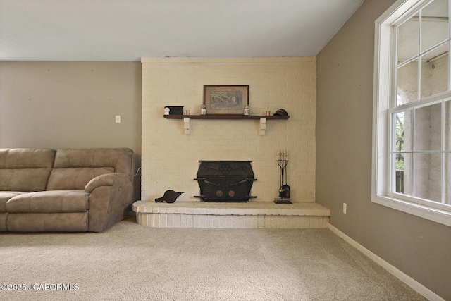living room featuring carpet floors, baseboards, and a fireplace