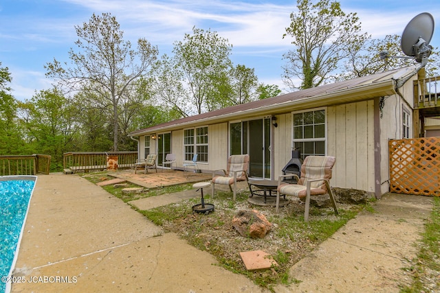 rear view of house featuring a patio, a wooden deck, and metal roof