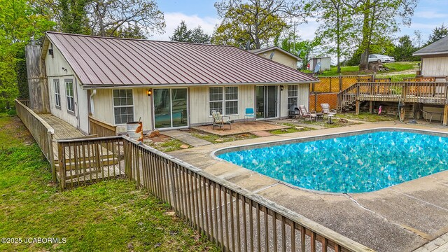 view of swimming pool featuring fence, a fenced in pool, a wooden deck, and stairs