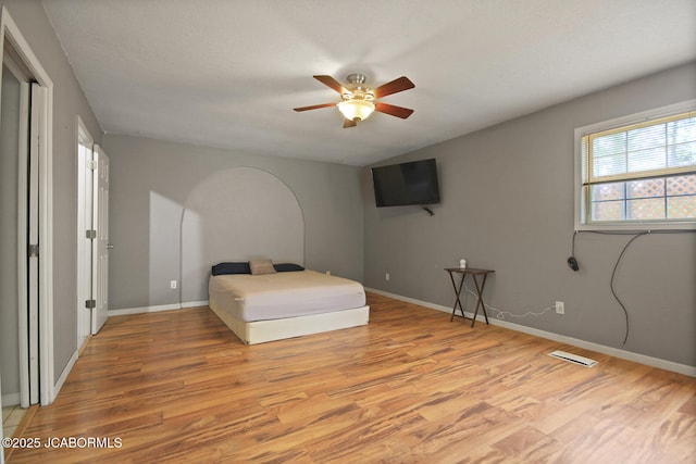 bedroom with visible vents, a ceiling fan, light wood finished floors, and baseboards