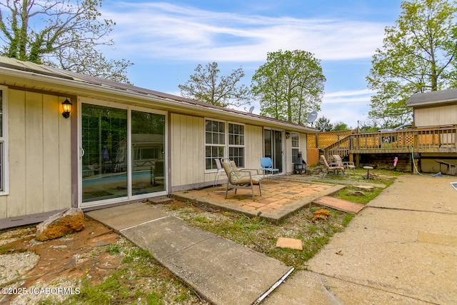 back of house with a wooden deck and a patio area