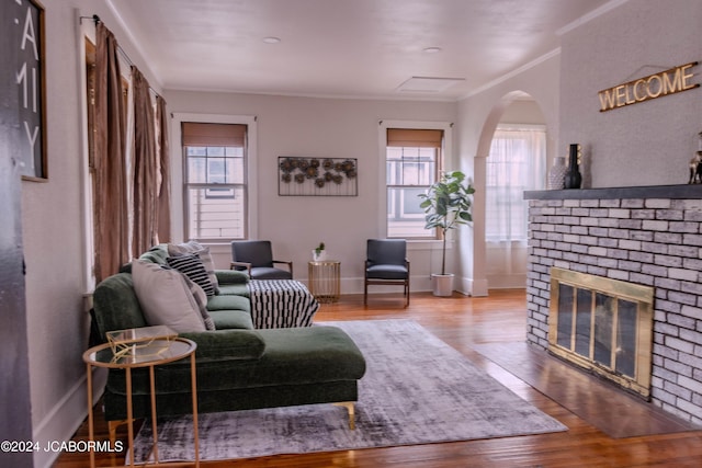 living room with a fireplace, wood-type flooring, and crown molding