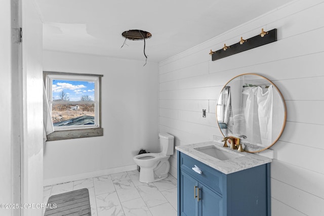 bathroom with toilet, marble finish floor, vanity, and baseboards