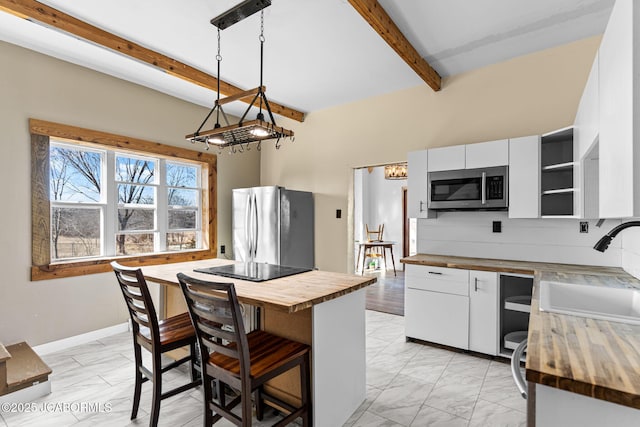 kitchen featuring open shelves, appliances with stainless steel finishes, white cabinetry, a sink, and butcher block countertops