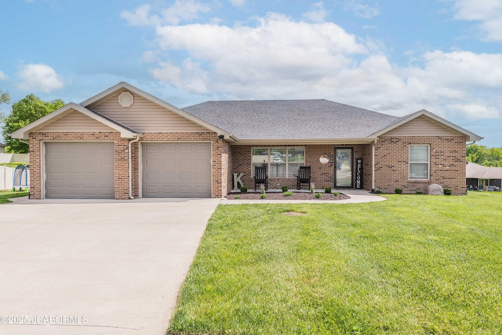 440 Dover Ct, Holts Summit, MO 65043 - view of front facade featuring an attached garage, a front lawn, concrete driveway, and brick siding