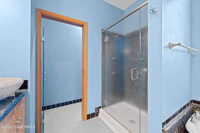 bathroom with tile patterned floors, vanity, and a shower with door