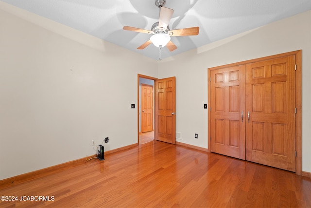 unfurnished bedroom featuring a closet, hardwood / wood-style flooring, and ceiling fan