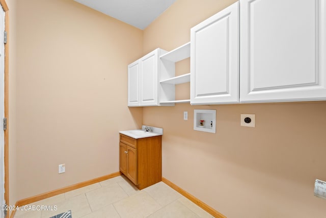 laundry area with hookup for an electric dryer, light tile patterned flooring, cabinets, and hookup for a washing machine