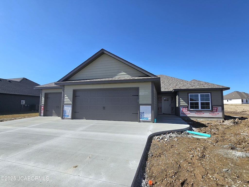 single story home featuring a garage and concrete driveway