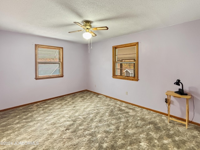 carpeted empty room featuring ceiling fan and a textured ceiling