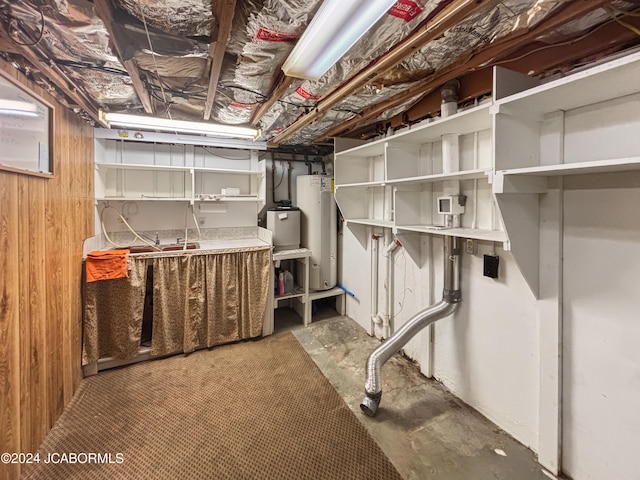 basement featuring electric water heater and wood walls