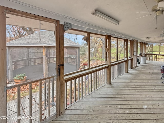 unfurnished sunroom featuring ceiling fan