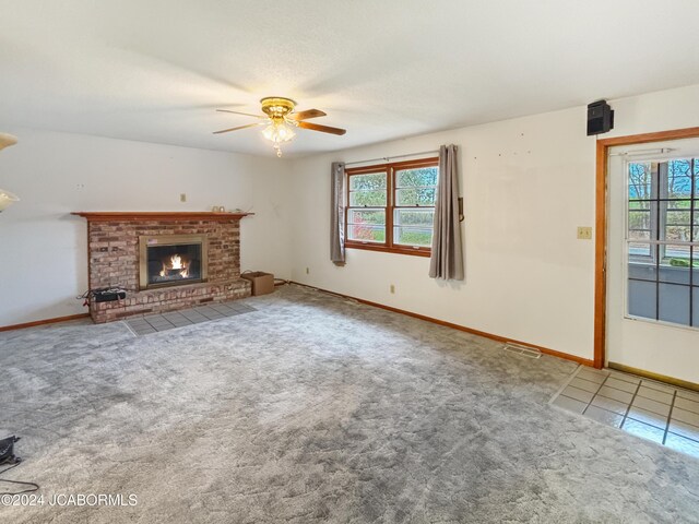 unfurnished living room with ceiling fan, carpet floors, and a fireplace