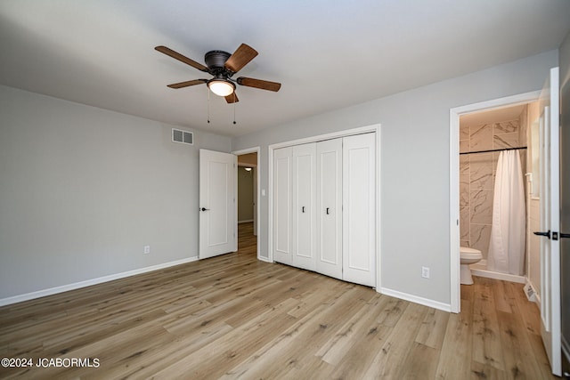 unfurnished bedroom featuring ceiling fan, a closet, ensuite bathroom, and light hardwood / wood-style flooring