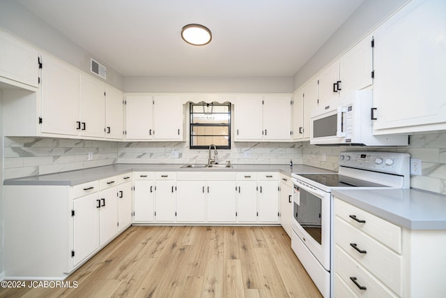 kitchen with light wood-type flooring, backsplash, white appliances, sink, and white cabinets