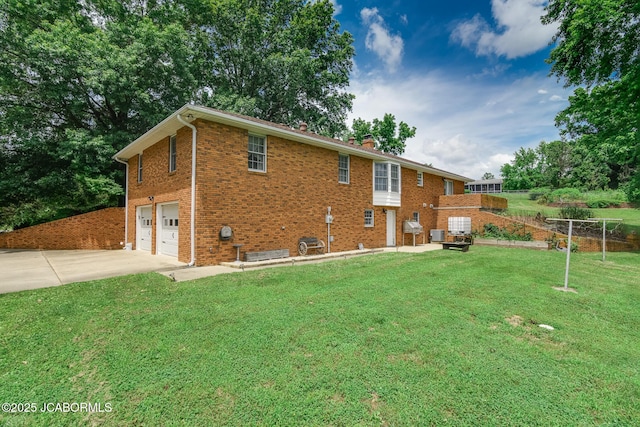 3609 Shamrock Rd, Jefferson City, MO 65101 - back of property featuring driveway, an attached garage, brick siding, a chimney, and a lawn