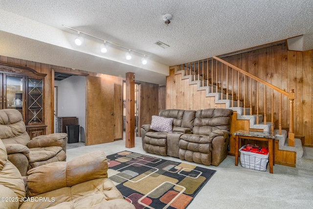 3609 Shamrock Rd, Jefferson City, MO 65101 - living area with wood walls, stairs, carpet, a textured ceiling, and rail lighting