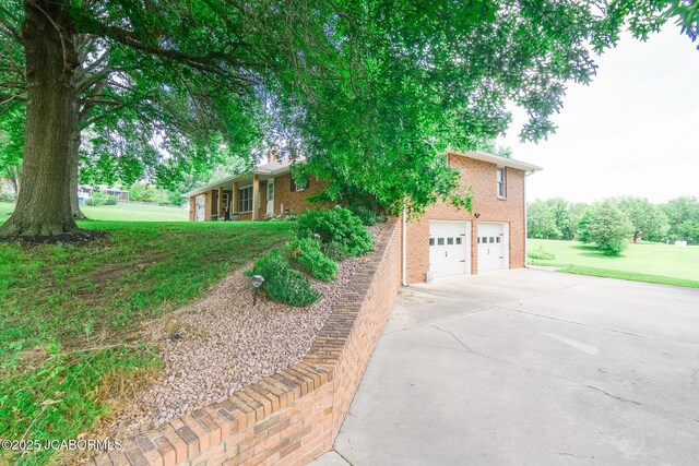 3609 Shamrock Rd, Jefferson City, MO 65101 - view of front facade featuring concrete driveway, brick siding, a front lawn, and a garage