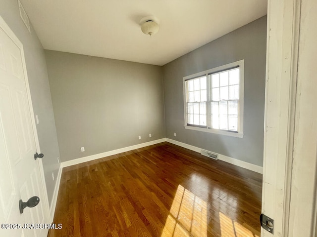 spare room featuring dark wood-type flooring