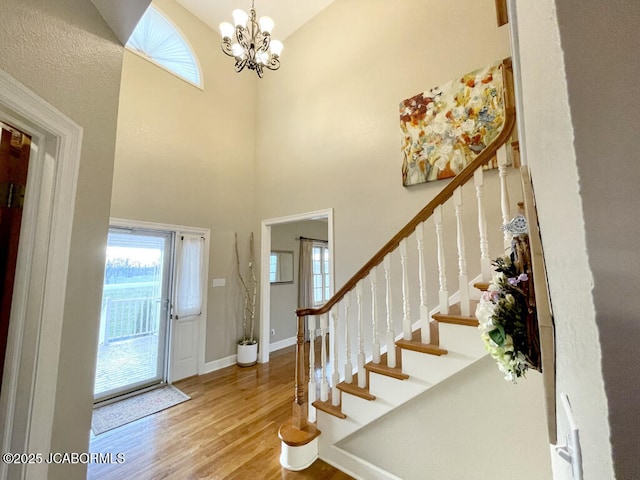 entryway featuring hardwood / wood-style flooring, a chandelier, and a high ceiling