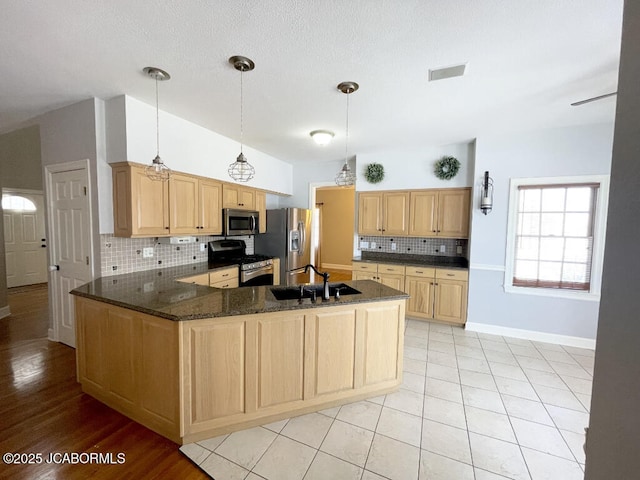 kitchen featuring pendant lighting, sink, backsplash, kitchen peninsula, and stainless steel appliances