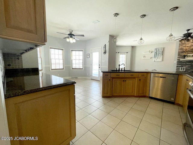 kitchen with pendant lighting, sink, dishwasher, ceiling fan, and dark stone counters