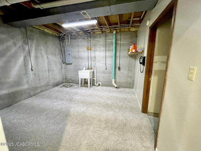 basement featuring electric panel and sink