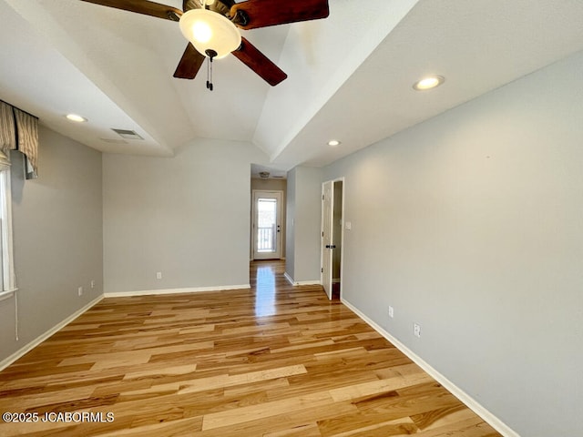empty room with vaulted ceiling, ceiling fan, and light hardwood / wood-style flooring