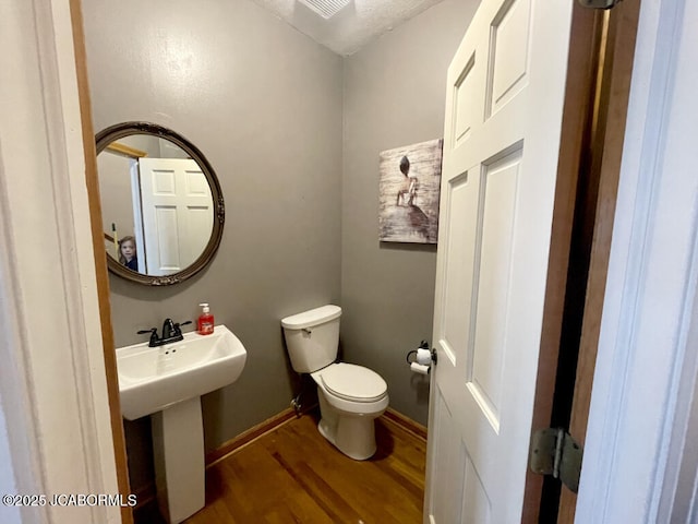 bathroom with wood-type flooring, sink, and toilet