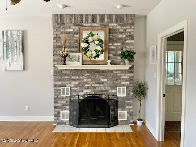 room details featuring hardwood / wood-style floors, a brick fireplace, and ceiling fan