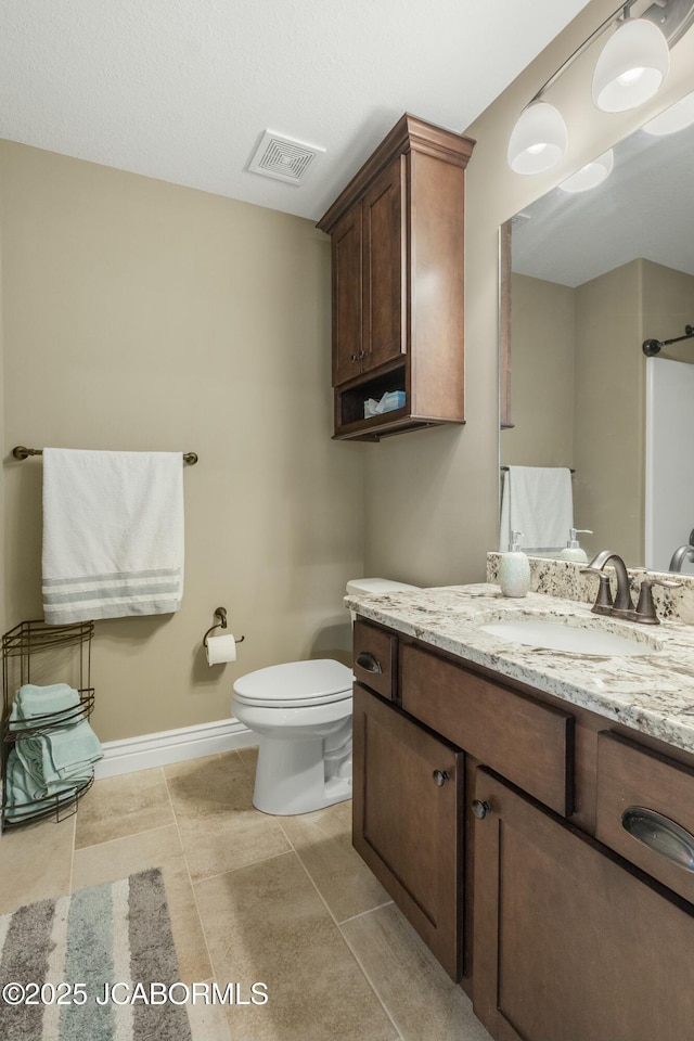 bathroom with vanity, toilet, visible vents, baseboards, and tile patterned flooring