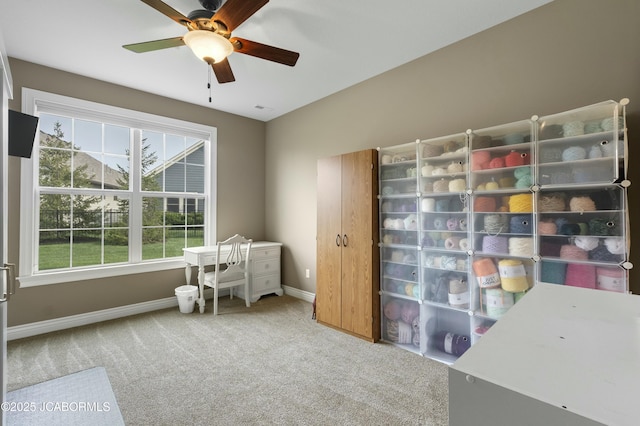 carpeted office with ceiling fan and baseboards
